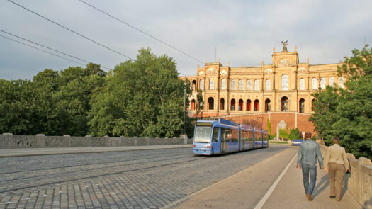 A streetcar (and a couple) on the bridge of river Isar, and under the Maximilianeum (Munich, Germany)