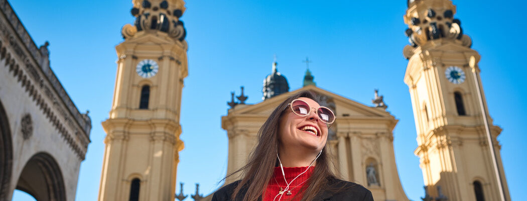 Young female tourist wearing sunglasses and earplugs downtown Mu