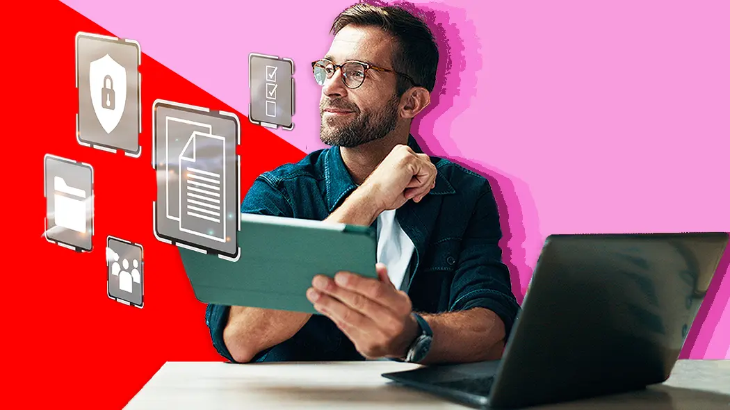 Ein Mann sitzt an einem Schreibtisch mit einem Laptop vor einem roten Hintergrund, während er digitale Bank-Tools betrachtet.