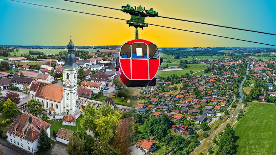 Eine rote Seilbahngondel fährt über eine ländliche Szenerie, die Ansichten von Erding und Aschau im Chiemgau kombiniert.
