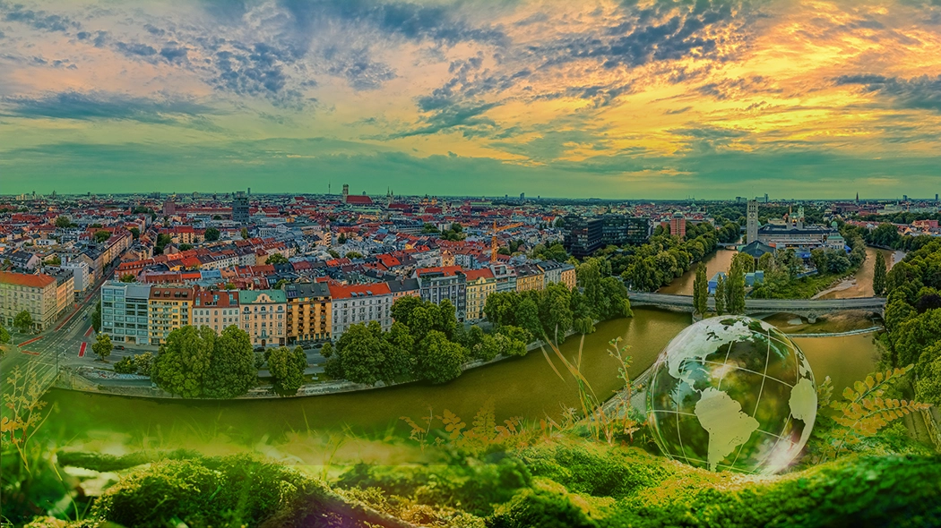 Eine weitläufige Panoramaaufnahme von München bei Sonnenuntergang, die die Isar und die dicht bebaute Stadtlandschaft unter einem dramatischen Wolkenhimmel zeigt. Der untere Teil des Bildes wird von einer collageartigen, saftig grünen Moos- und Farnlandschaft eingenommen, die wie ein natürlicher Rahmen wirkt. Inmitten dieser grünen Zone, im rechten Vordergrund, schwebt eine gläserne Weltkugel, in der sich die Wolken und das Licht spiegeln. Die gesamte Szenerie ist in warme, goldene und frische grüne Farbtöne getaucht, was eine harmonische Verbindung von Urbanität und Naturschutz symbolisiert.