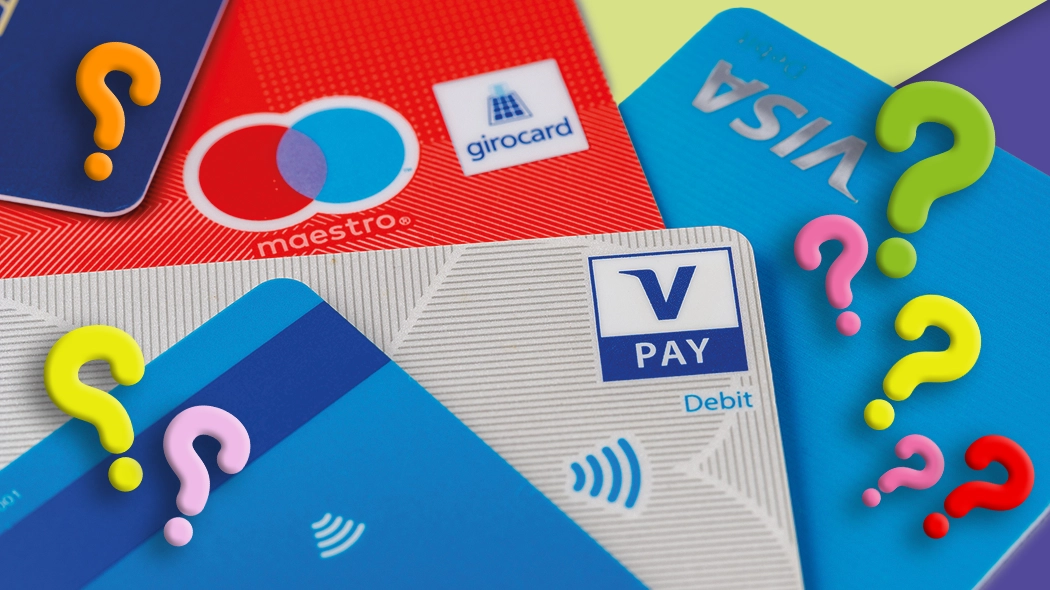 Unterschied zwischen Girocard, Debit- und Kreditkarte: Verschiedene Bankkarten mit Fragezeichen zur Erklärung.